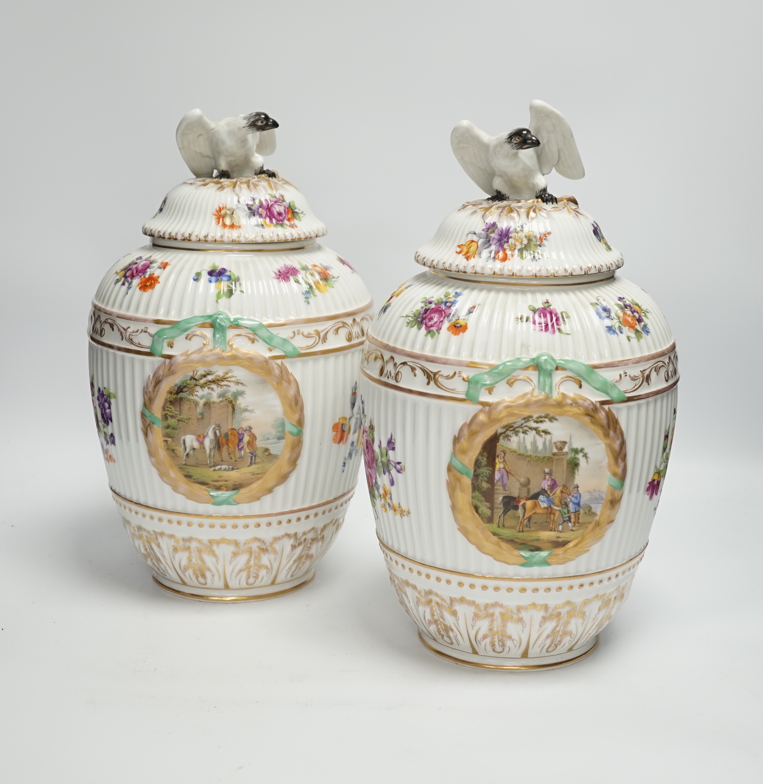 A pair of Continental floral decorated ribbed jars and covers with figural cartouches, 32cm high